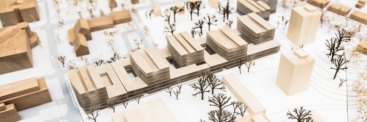 3-D-Modell einer Idee, wie das Theoretikum aussehen könnte. Zu sehen ist die Bestandsbebauung auf dem Weinberg Campus aus Holz. Zentral liegt der Gebäuderiegel aus Holz und transparentem Material, den ein Wettbewerbssieger als städtebauliche Entwurfsidee eingereicht hat.