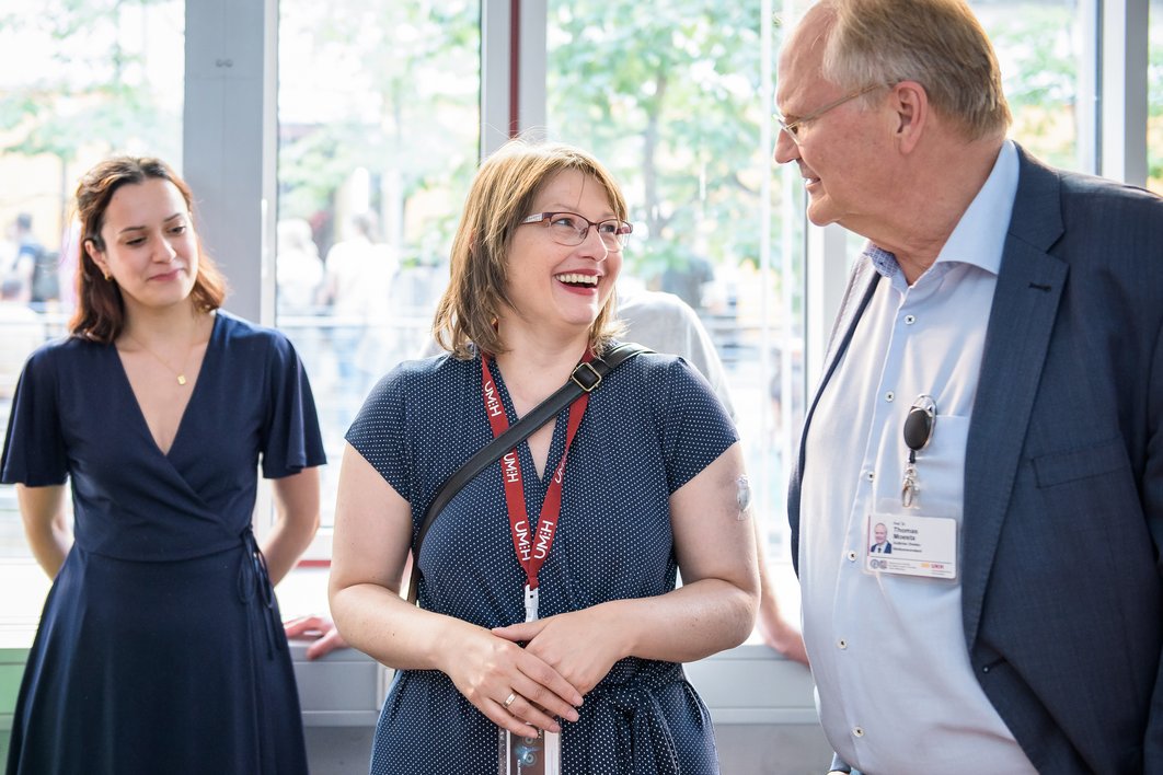 Dr. Katja Pähle lacht und schaut Prof. Dr. Thomas Moesta an; eine Frau steht links von beiden und schaut sie an.