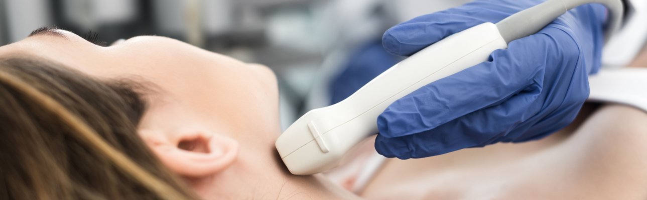Frau liegend mit einem medizinischem Gerät zur Schilddrüsenuntersuchung am Hals